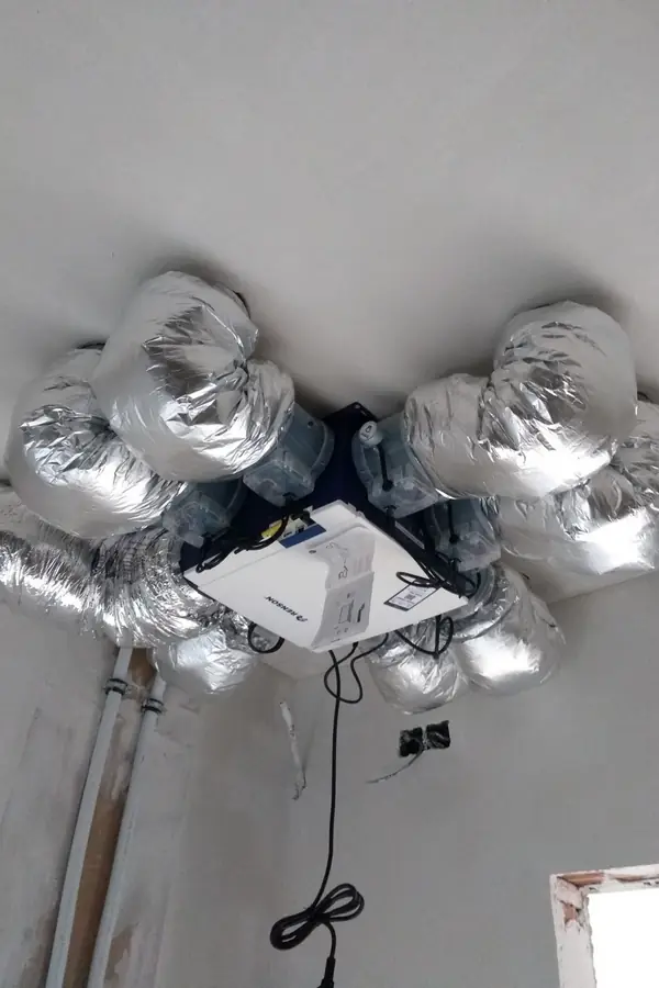 Ventilatie-unit tegen het plafond, met geïsoleerde kanalen naar alle kanten