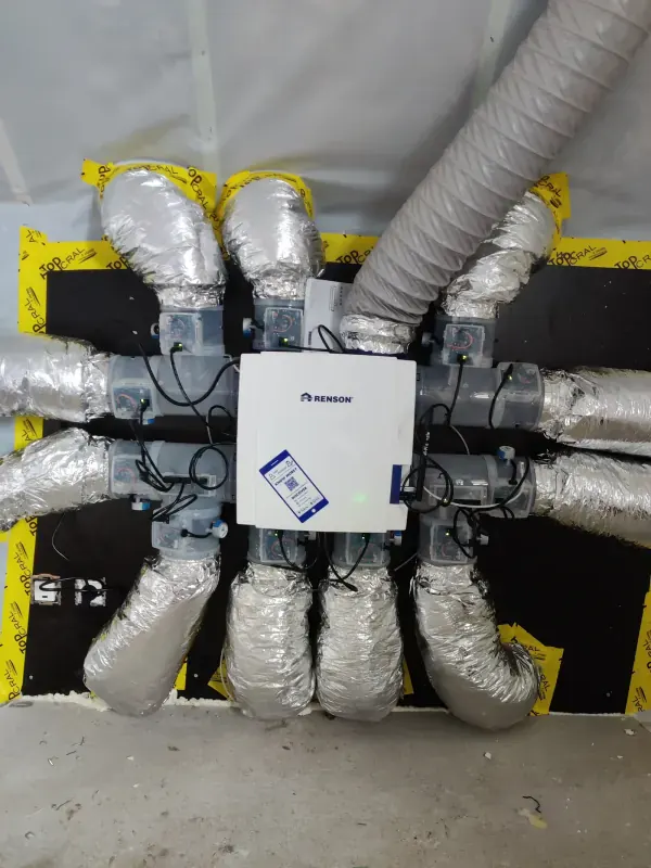 Renson-ventilatie-unit tegen het plafond, met geïsoleerde kanalen naar alle kanten