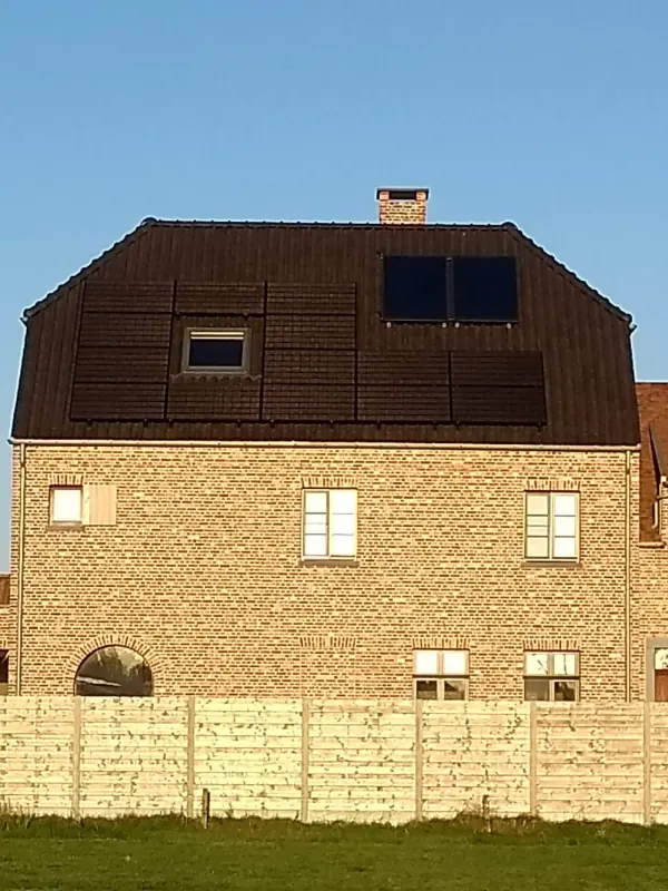 Mansardedak dat bijna volledig bedekt is met zwarte zonnepanelen